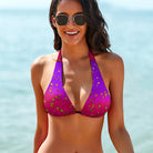 This is a tight-cropped photo of the model's front showing her swimsuit top.  Model has black hair and is wearing black gold-framed sunglasses.  She has mid-length black hair, with the ocean out of focus in the background. The model's arms are by her side and she is looking into the camera. Model is showing the Salt Skins Separates Collection Bikini Top and Swimsuit, which has a bold pink fade to purple with green dots on the bikini top.