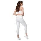 A back view of a white-skinned girl shows her cropped workout bra and beautiful white light-patterned yoga pants with a double-layered flat front waist. She is also wearing white tennis shoes to match her white athletic pants, and her hands are in front of her.