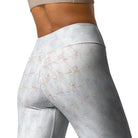 A closeup of a girl wearing a tan workout bra. She is wearing lovely white yoga leggings (shown from the back) with a double-layered waist and the white leggings have subtle check patterns. The image is cropped and you can only see her athletic pants from the things up to her workout bra.