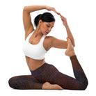 A girl in Yoga Pose is Sitting on the Ground against a white background. She is wearing Salt Skins, Black-Colored Flecks, Yoga, and Workout Pants. She is also wearing a white workout top.