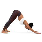 Girl in Yoga Pose is leaning forward with her hands on the ground, and the photo is taken on a white background, wearing Salt Skins, Black Color Flecks Yoga, and Workout Pants. She is also wearing a white workout top.